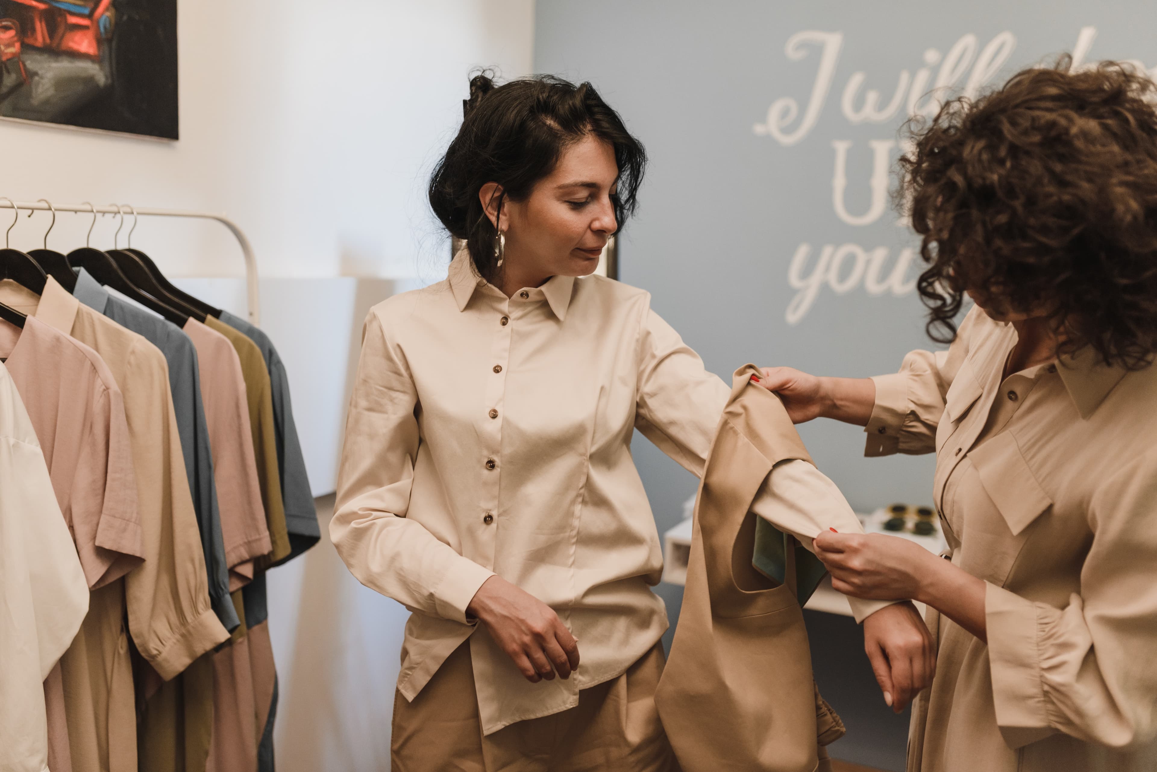 woman in store fitting on a beige waistcoat 