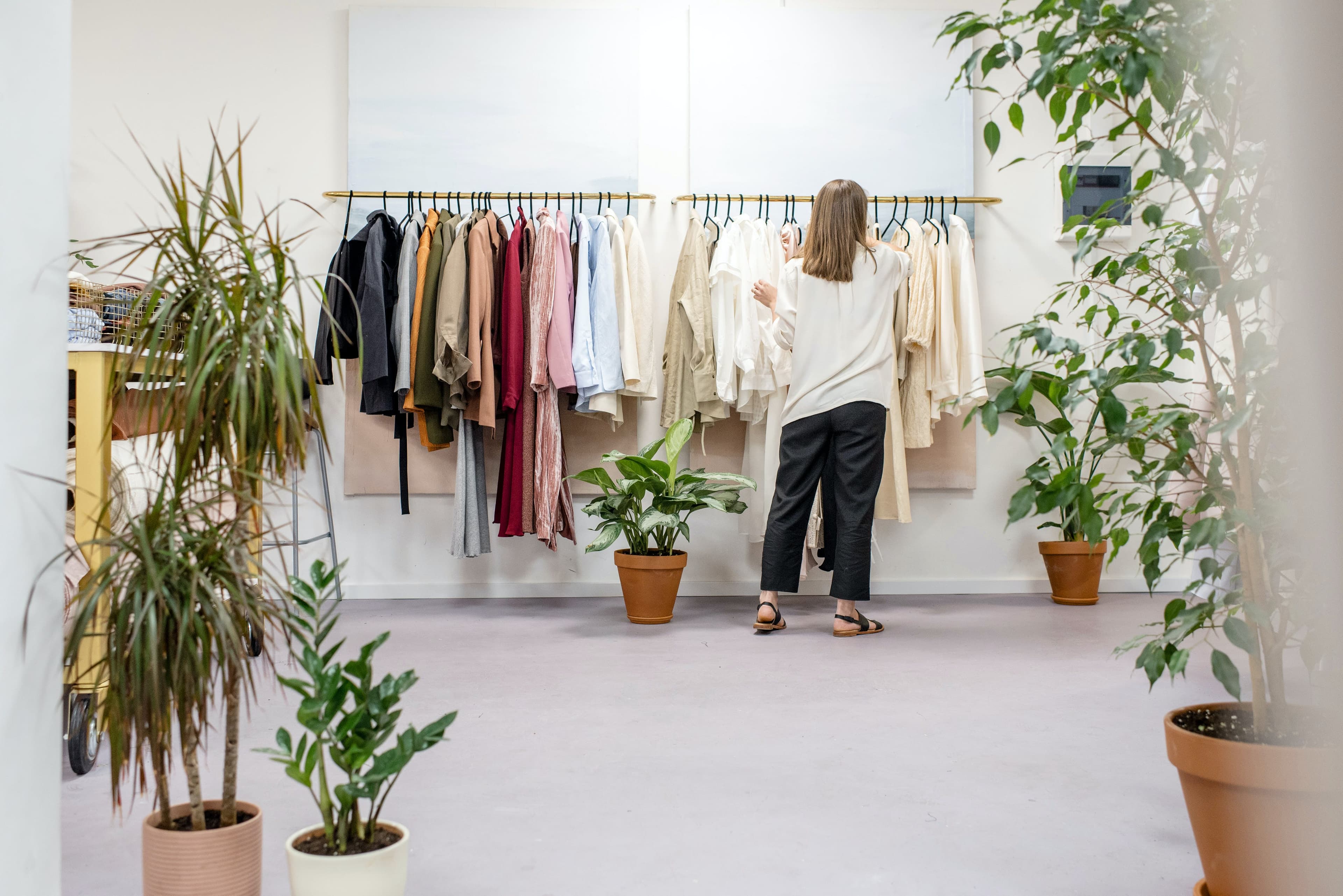 Woman Fixing Clothes on a Rack in a clothing store