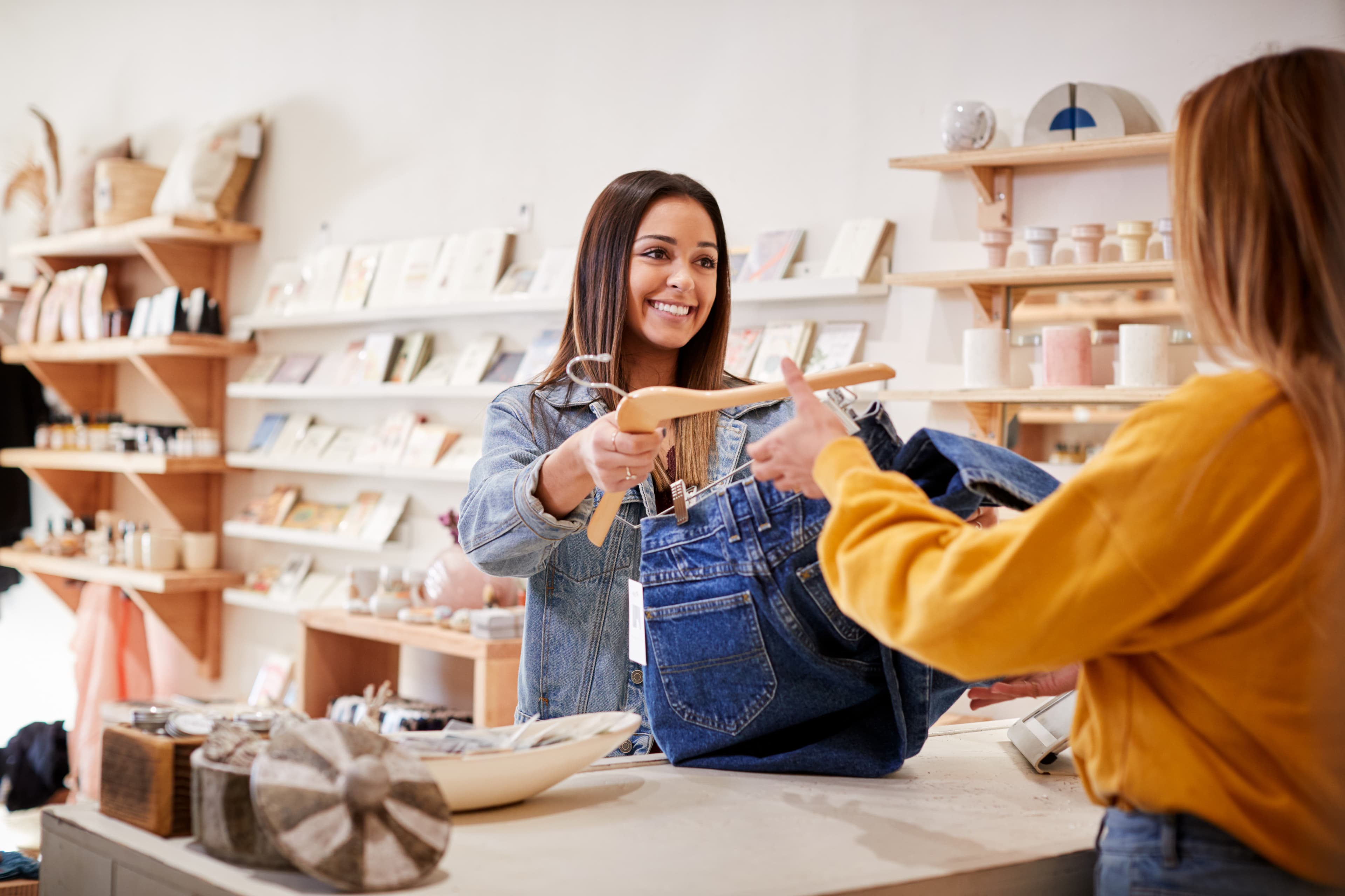 Female Sales Assistant In Clothing And Gift Store Serving Female Customer